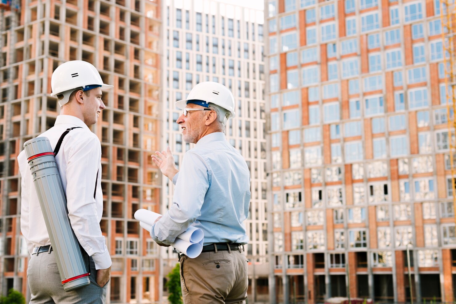 Commercial construction project with a consultant discussing building plans with a site engineer at a modern high-rise construction site.