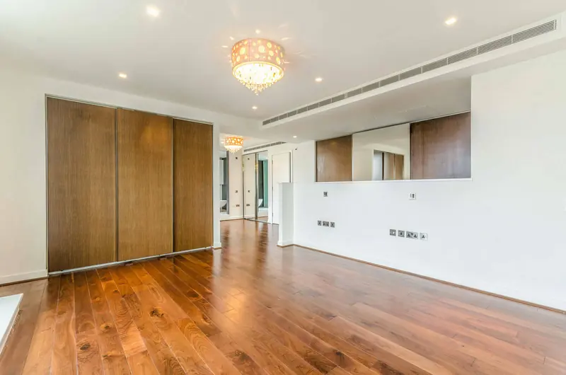 Apartment living space with walnut floor and chandelier