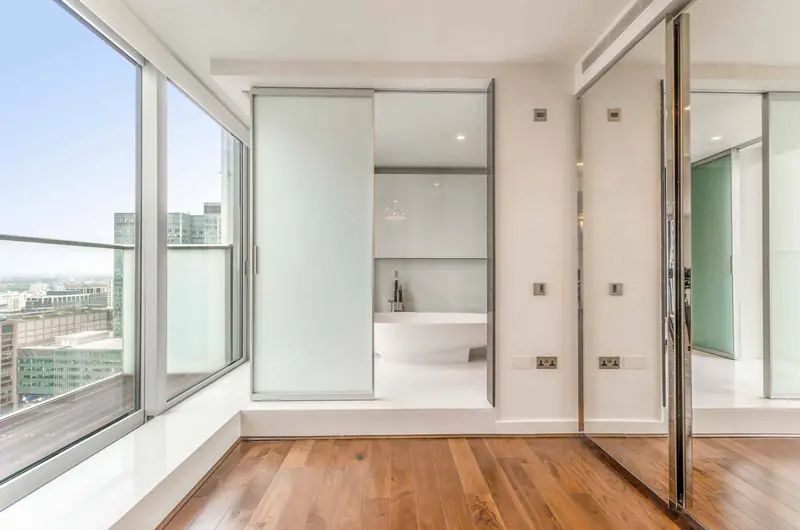Apartment with glazed bathroom doors and timber floor