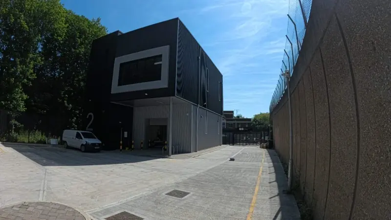 Black-clad building beside a railway wall