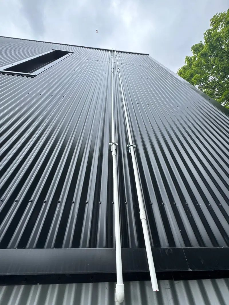 Black standing-seam cladding on a new building, looking up