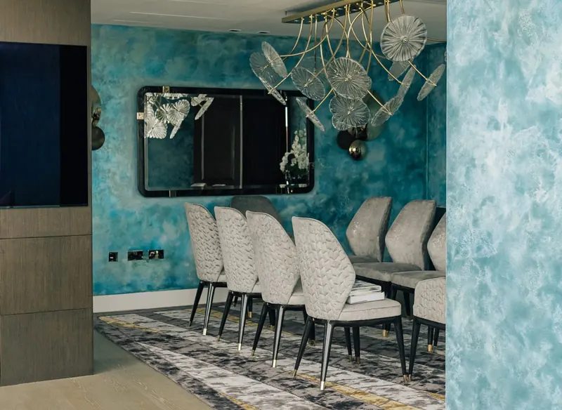 Dining room with upholstered chairs and turquoise polished plaster