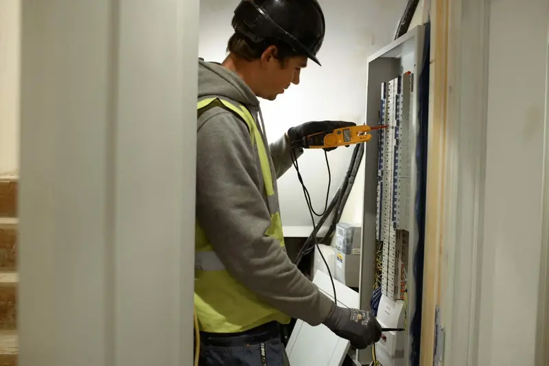 Electrician testing wiring at a consumer unit