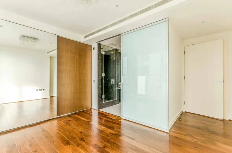 Finished hallway with a walnut floor and sliding doors