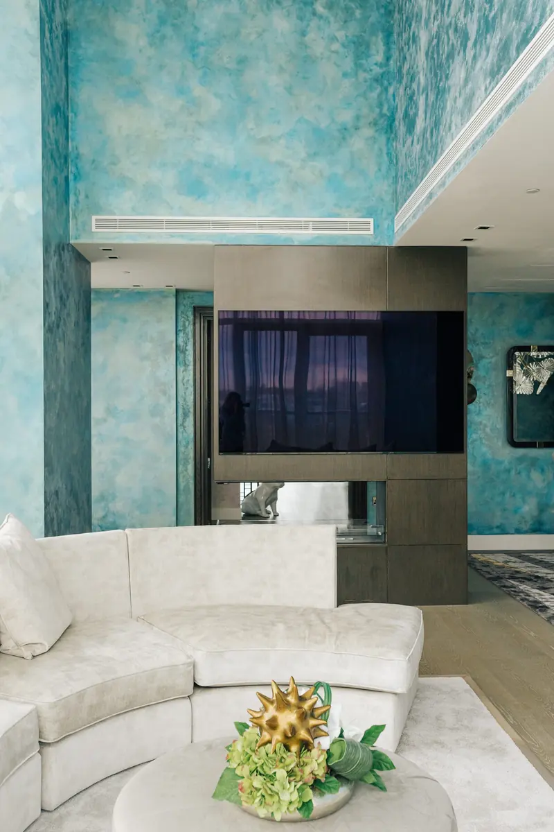 Living room with a curved sofa and polished plaster walls