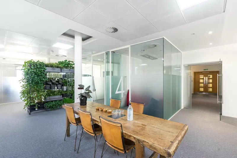 Office breakout area with green wall and glass meeting room