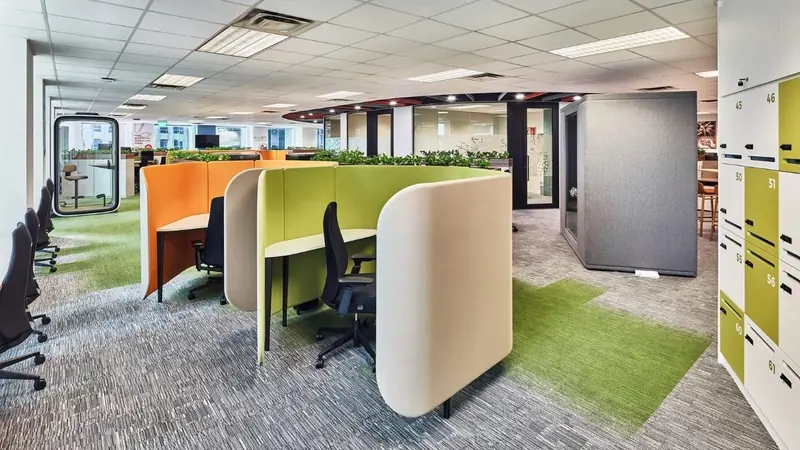 Office floor with upholstered booths and green carpet