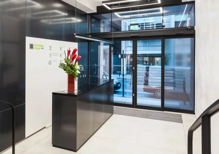 Office reception with dark panelling and a stone floor