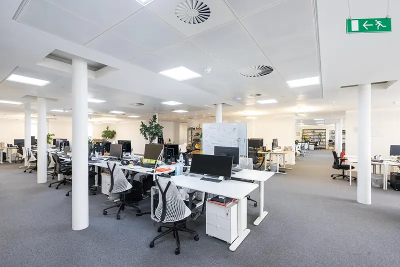 Open-plan office with desks between white columns