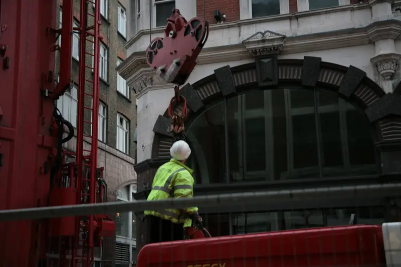 Operative beside a crane at a listed building entrance