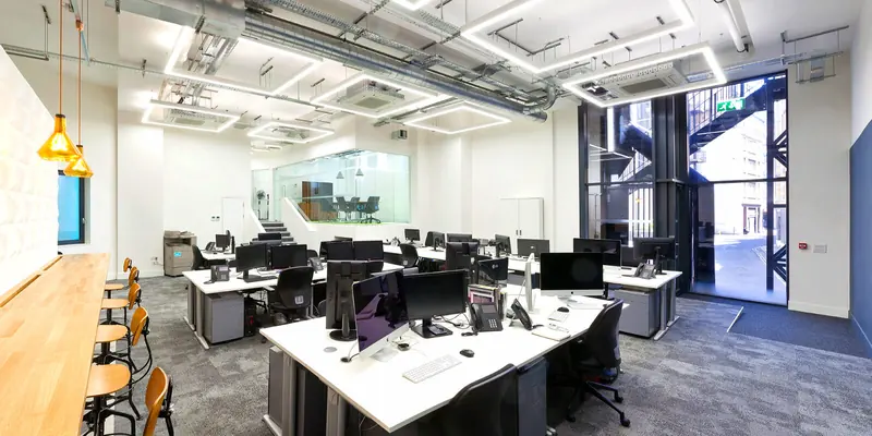 Refurbished office floor with desks and a glazed entrance