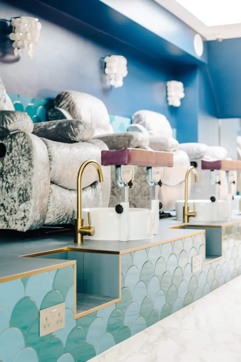 Salon wash basins with gold taps and patterned tiles