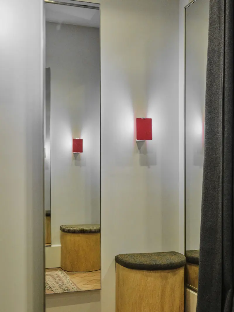 Shop fitting room with timber panelling and a curtain