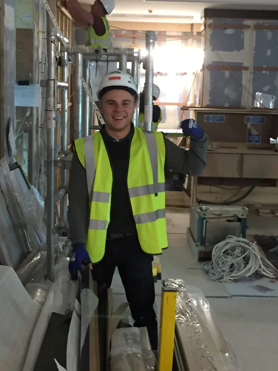 Smiling operative in a hard hat and hi-vis on site