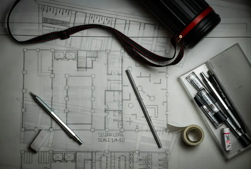 Architectural drawings with drafting pencils, ruler and a plan tube