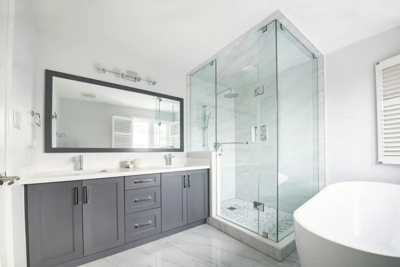 Bathroom with a frameless glass shower and grey double vanity