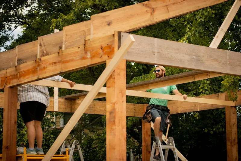 Builders putting up a timber frame