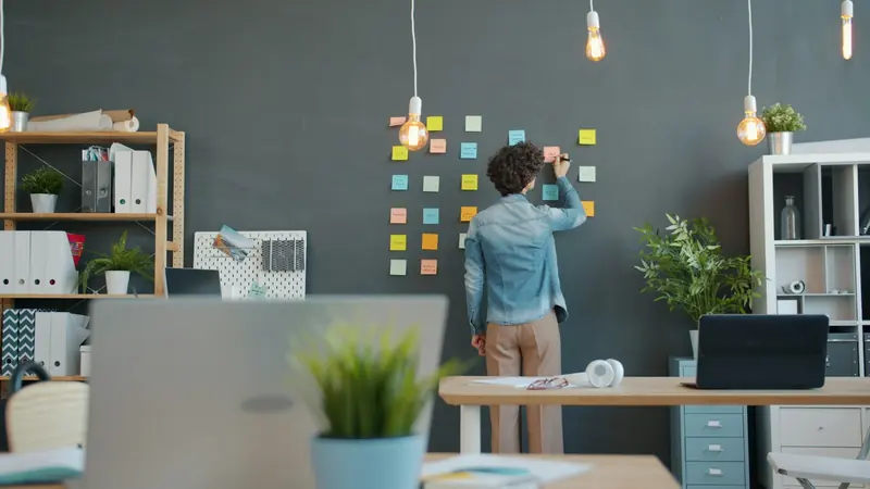 Business owner arranging sticky notes on a planning wall
