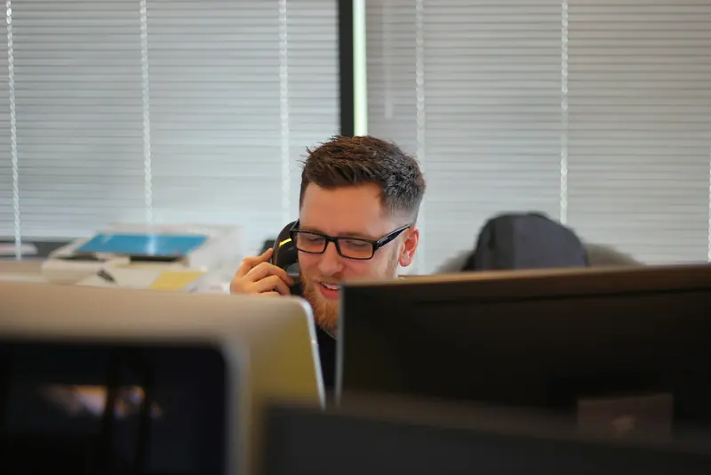 Business owner on a desk phone in a small office