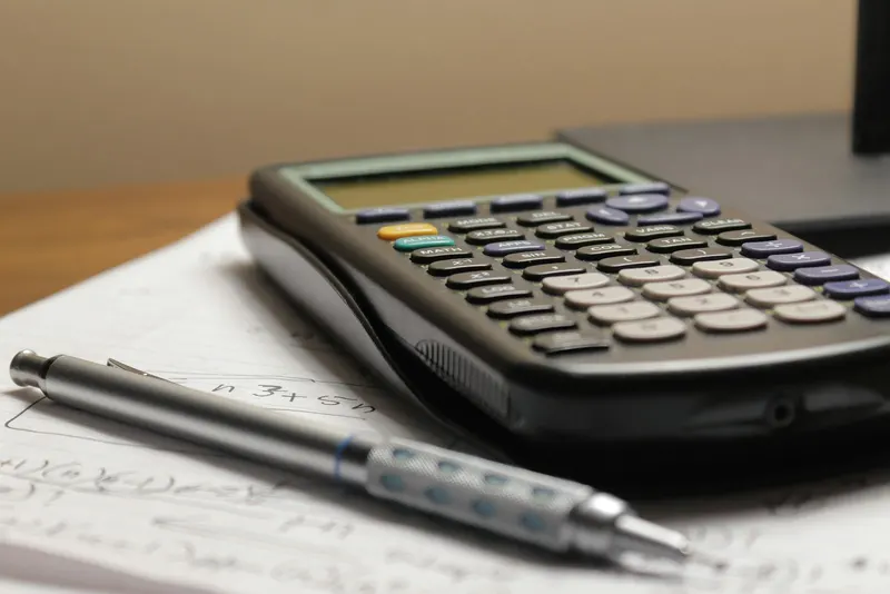 Calculator and pen on a printed sheet of figures