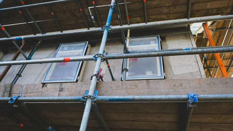 Close-up of scaffold tubes and boards against a building