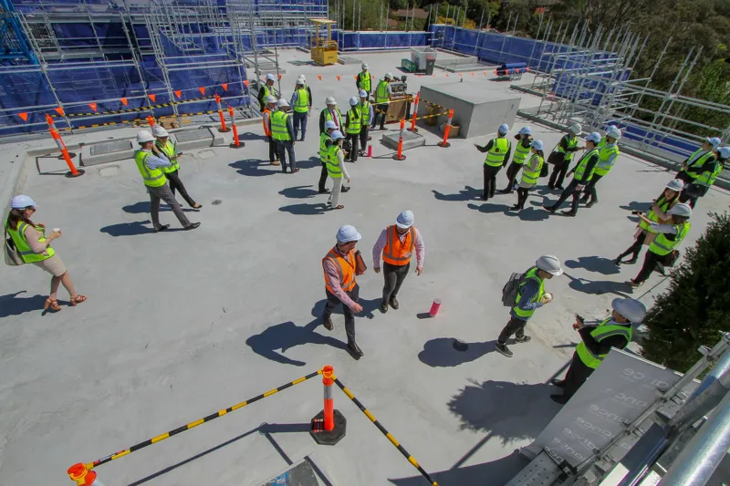 Site operatives in hi-vis and hard hats on a roof slab during works