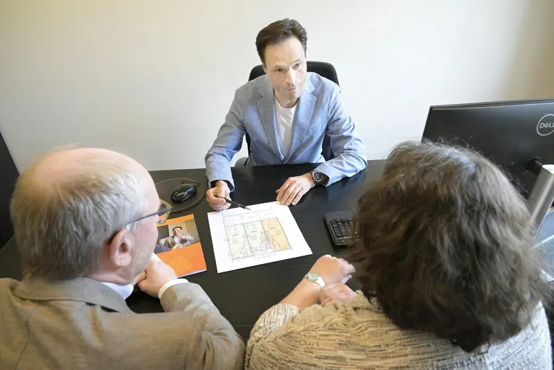 Consultant talking a couple through plans at a desk
