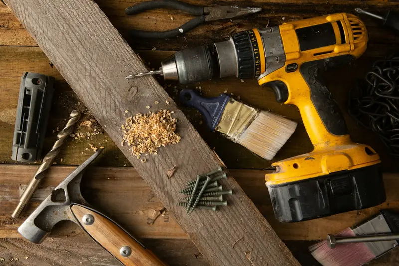 Cordless drill and hand tools on a timber workbench
