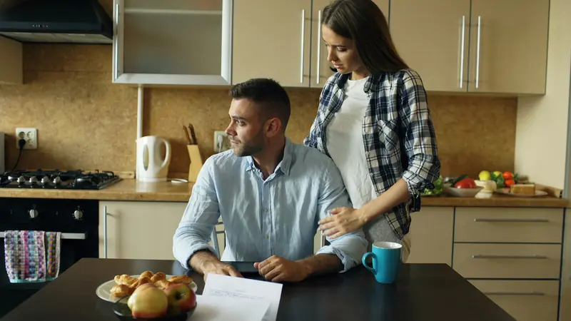 Couple going through paperwork at a kitchen table