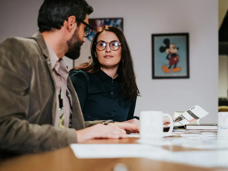 Couple sitting at a table going through plans in a meeting