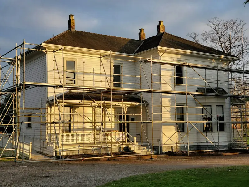 Detached house wrapped in scaffold for refurbishment