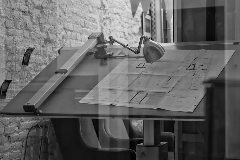 Drawing board with plans under an anglepoise lamp