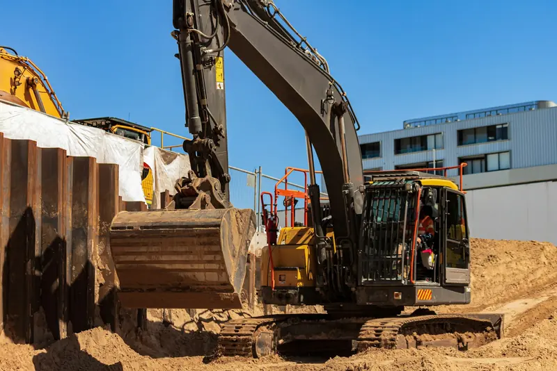 Excavator beside sheet piling on an urban basement dig