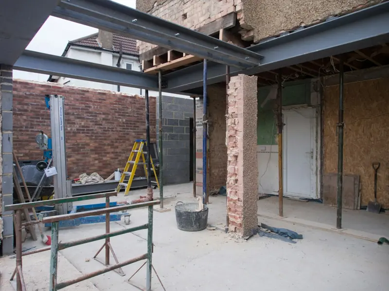 Ground-floor extension shell with new steel, step ladder and brick walls