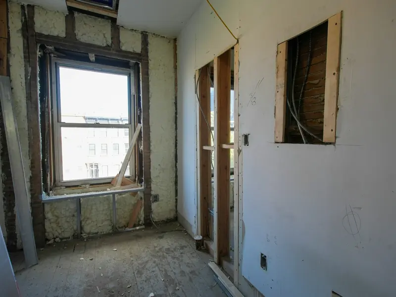 Gutted room with new plasterboard walls and window openings