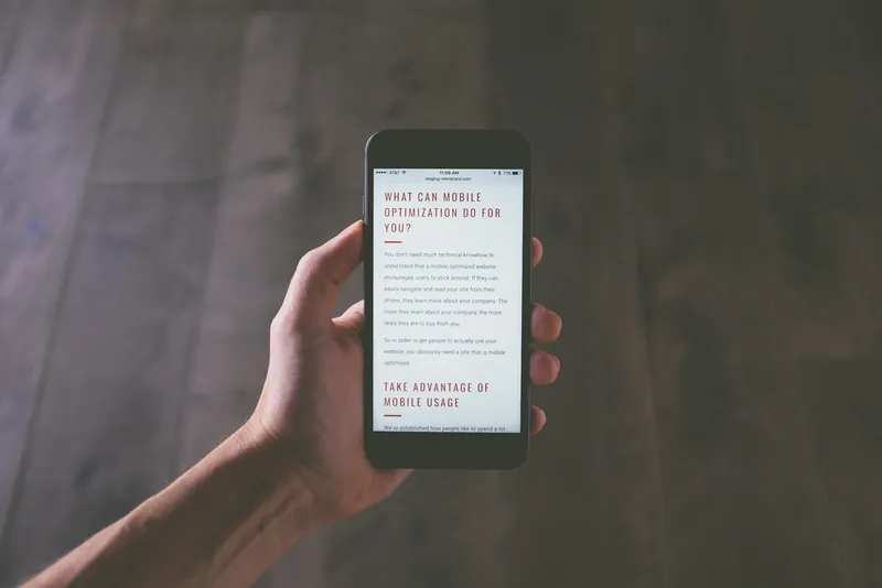 Hand holding a smartphone with a web page on screen
