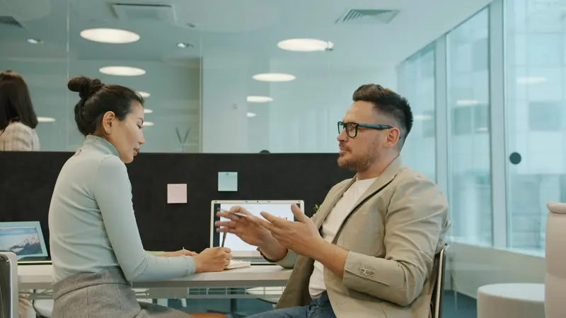 Interview under way at a desk in an open-plan office