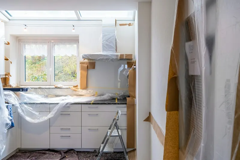 Kitchen cabinets wrapped in plastic during a renovation