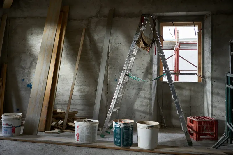 Ladder and paint buckets in a room under construction