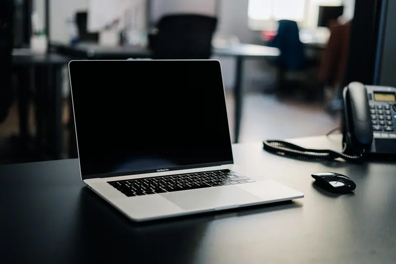 Laptop and desk phone on a tidy office desk