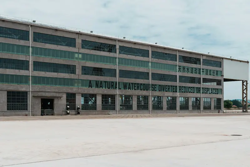 Long industrial warehouse building with a concrete yard