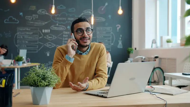 Man on a phone call in a bright office