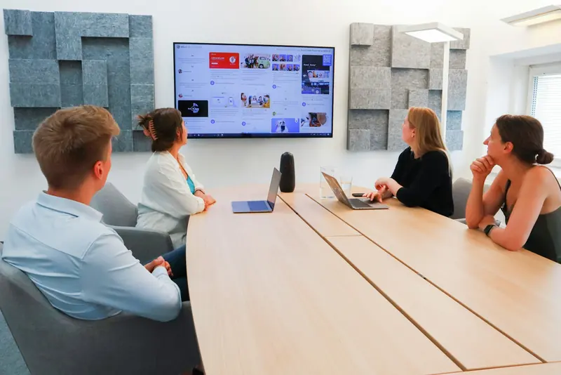 Meeting round a conference table with a screen