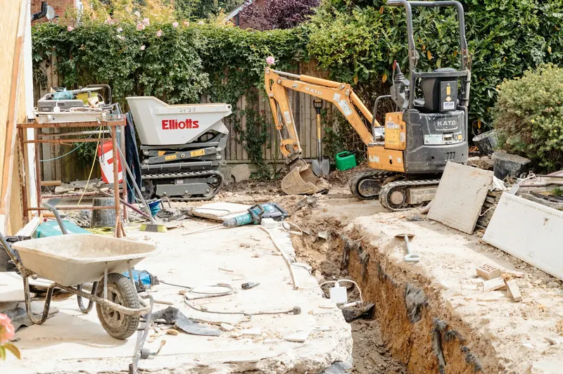 Mini excavator digging a trench in a back garden