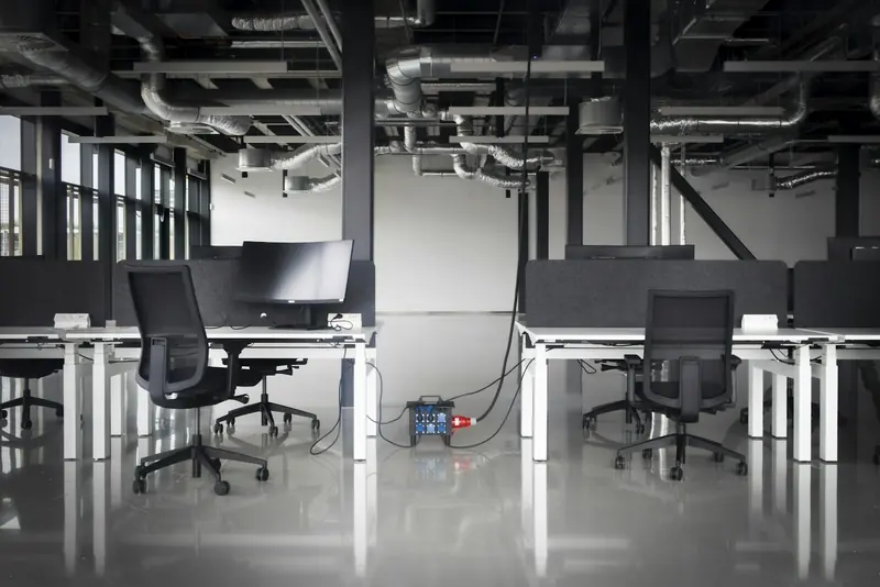 Newly fitted open-plan office with desks and exposed services
