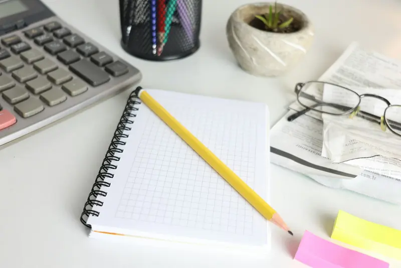 Notepad, pencil and keyboard on an office desk