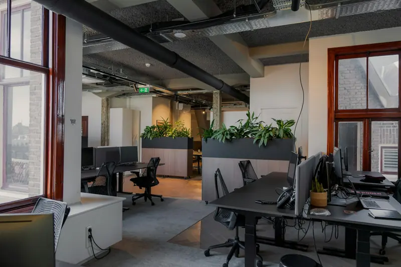 Office with desks, planters and exposed ceiling