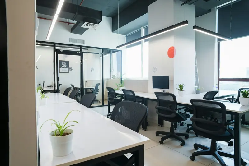 Open-plan office with white desks and glass meeting rooms