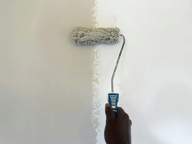 Painter using a roller on an interior wall