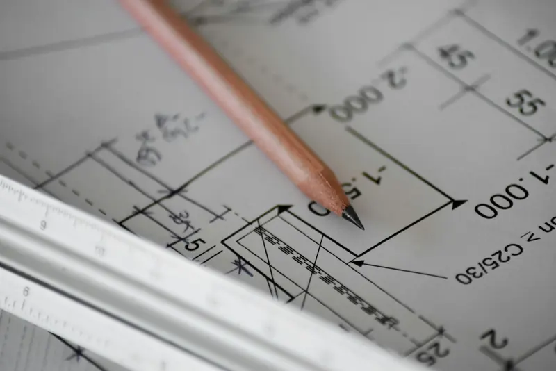 Pencil resting on printed architectural drawings